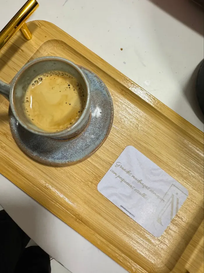 Café servido em bandeja de madeira, com um cartão do Instituto Nogueira escrito: grandes mudanças começam com pequenas escolhas